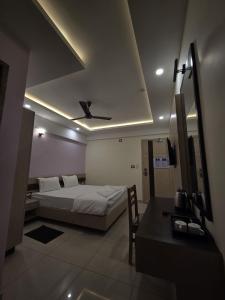 a bedroom with a bed and a ceiling fan at Krishnavasyam lodging in Uppinangadi +10 photos