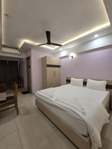a bedroom with a bed and a ceiling fan at Krishnavasyam lodging in Uppinangadi