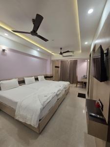 a bedroom with a large bed with a ceiling fan at Krishnavasyam lodging in Uppinangadi