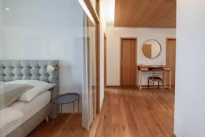 a bedroom with a bed and a table and a mirror at Loft in Seenähe im Herzen von Bregenz in Größing +2 photos
