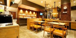 restauracja ze stołami i krzesłami oraz barem w obiekcie APA Hotel Chiba Inzaimakinohara-Ekimae w mieście Narita