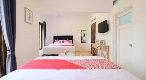 a bedroom with a large bed with red and white sheets at OYO 2118 Fh Stay in Yogyakarta