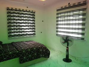 Ένα ή περισσότερα κρεβάτια σε δωμάτιο στο Cozy 3-Bedroom Tradebybata Guest House FUNAAB