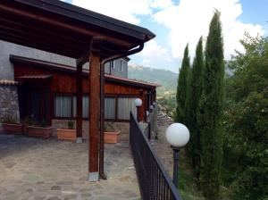 a house with a porch with a fence and trees at Masseria degli Alberti in Mormanno