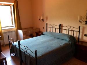 a bedroom with a bed with a blue blanket on it at Masseria degli Alberti in Mormanno