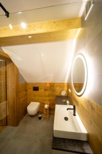 a bathroom with a sink and a toilet and a mirror at Siedlisko Pod Szczerbakiem in Szczawnica