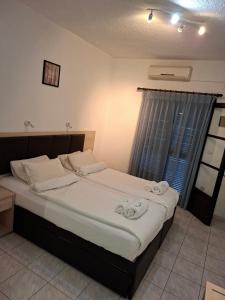a bedroom with a large bed with towels on it at Tassos 2 in Pefkochori