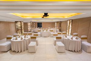 a banquet hall with white tables and white chairs at Sterling Palm Bliss - Rishikesh in Rishīkesh