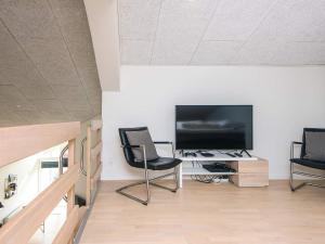 a living room with two chairs and a flat screen tv at 8 person holiday home in Ringkøbing in Ringkøbing +122 photos