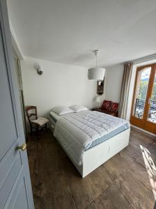 a bedroom with a bed and a chair and a window at L'etoile Filante in Formiguères