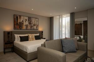 a bedroom with a bed and a couch at Lux Leisure Apartment Hotel Sandton in Johannesburg