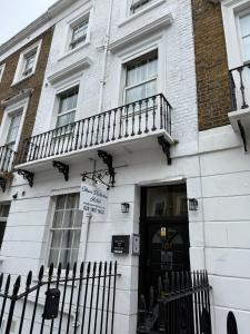 a white building with a black door and a balcony at Oban Victoria Hotel in London