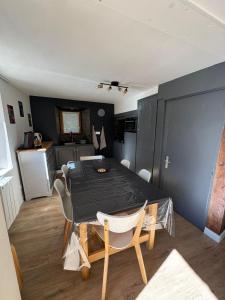 a dining room with a table and a kitchen at L'etoile Filante in Formiguères
