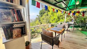 a balcony with a table and chairs and books at Green Mandala Inn in Kathmandu