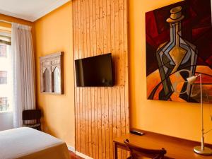 a bedroom with a bed and a painting on the wall at La casa de la escritora in Madrid