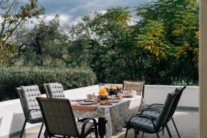 a table with food and chairs on a patio at Olive Grove Retreat in Mytilini