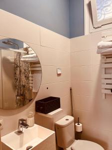a bathroom with a toilet and a sink and a mirror at La casa de la escritora in Madrid