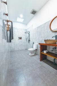 a bathroom with a toilet and a sink at Villa Dot -Beach Front and private pool villa in Gili Air