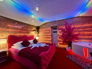 a bedroom with a red bed and a bath tub at APARTAMENT Solny SPA in Rzeszów +15 photos