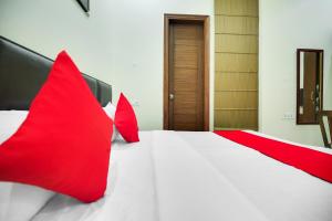 ルディヤーナーにあるHotel O Sky Lineのベッドルーム(白いベッドに赤い枕付)