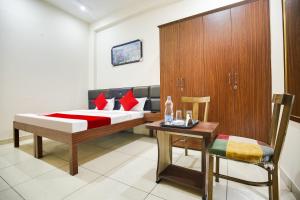 ルディヤーナーにあるHotel O Sky Lineのベッドとテーブルと椅子のある寝室
