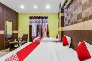 a hotel room with two beds with red pillows at Hotel O Crystal Near Gomti Riverfront Park in Chinhat
