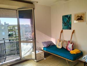 Una habitación con un banco con dos guitarras en un balcón. en Camere Artisti Musicisti Viaggiatori Vacanze, en Verona