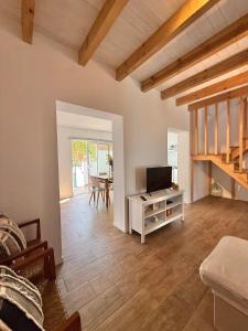 a living room with a television and a table at CAPARICA BEACH VILLA in Trafaria