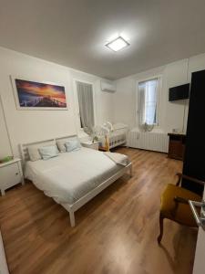AltedoにあるB&B Elenaの白いベッドとウッドフロアのベッドルーム1室