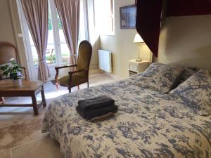 a bedroom with a bed with a bag on it at Les Eaux Calmes in Talcy