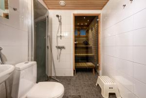 Un baño con inodoro y ducha a ras de suelo. en Aurinkorinne1 - Skistar spacious apartment with sauna, en Syöte 22 fotos más
