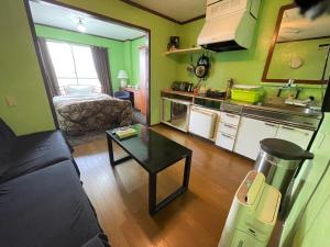 a kitchen with a couch and a table in a room at Guest House Koza Gate2 in Okinawa City