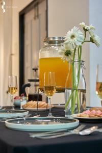 een tafel met glazen wijn en een vaas met bloemen bij Privy Stays- Cavo Villa, Alibag in Mān