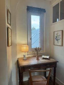 a table with a lamp and a window in a room at Maison Les Planches Trouville in Trouville-sur-Mer