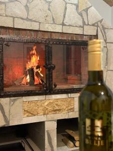 a bottle of wine in front of a fireplace at Apartman Ana in Kupres