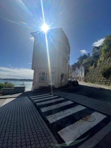 a lighthouse with the sun shining on top of it at Le Duplex de la côte in Dinard
