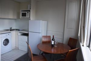 eine Küche mit einem Tisch und einer Flasche Wein in der Unterkunft Accommodation Sydney City Centre - Studio Apartment with Hyde Park View in Sydney