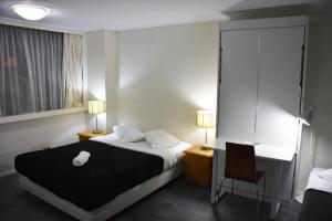 ein Schlafzimmer mit einem Bett und einem Schreibtisch mit Stuhl in der Unterkunft Accommodation Sydney City Centre - Studio Apartment with Hyde Park View in Sydney + 6 Fotos