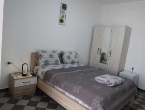 a bedroom with a bed and a dresser with a night stand at Apartmani Krnić in Tuzi