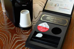 a remote control in a box next to a bottle of wine at OYO Ryokan Hamanako no Yado Kosai - Vacation STAY 38823v in Kosai