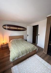 a bedroom with a bed with a surfboard on the wall at Le Duplex de la côte in Dinard