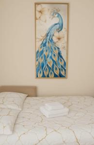 a painting of a peacock is hanging above a bed at Nowe luksusowe Apartamenty MANUFAKTURA-Prywatny na wyłączność-Wanna-Zamykany ogrodzony Parking, Blok,Niskie pietro-cisza i spokój in Łódź