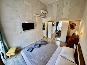 una stanza con un letto e una TV a parete di Venustas Napoli a Napoli