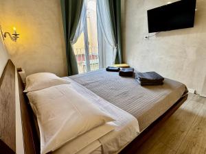 una camera con letto e TV a schermo piatto a parete di Venustas Napoli a Napoli Altre 42 foto