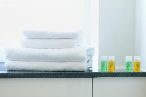 a stack of towels on a counter in a bathroom at HOMEFY - Gasthaus Düsseldorf - Meerbusch in Meerbusch +23 photos