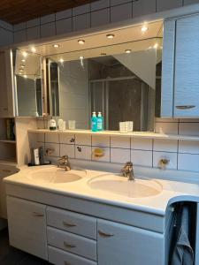 a bathroom with two sinks and a large mirror at Ferienwohnung Jägerhaus in Walldürn +22 photos