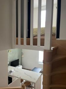 a living room with a table and a staircase at Le Duplex de la côte in Dinard