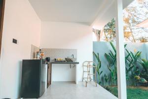 a kitchen with a black refrigerator and a table at Villa Dot -Beach Front and private pool villa in Gili Air