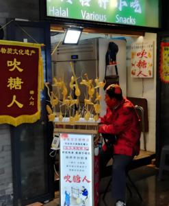 a man in a red jacket standing in front of a store at Sincer Hotel - Temple of Heaven Beijing Tiananmen Square in Beijing