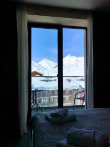 - une chambre dotée d'une fenêtre offrant une vue sur les montagnes enneigées dans l'établissement GVC 510 New Gudauri Mountain view, à Goudaouri